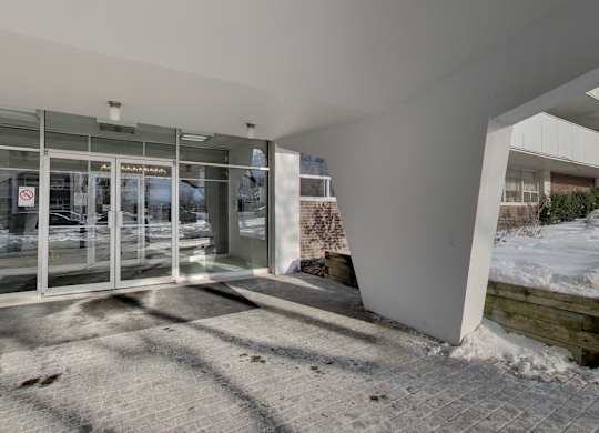 the entrance of a building with glass doors and a sidewalk