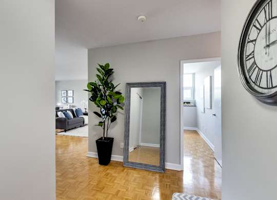 a living room with a large clock on the wall and a mirror