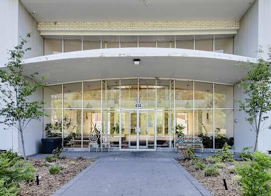 the entrance of a building with glass doors and a courtyard