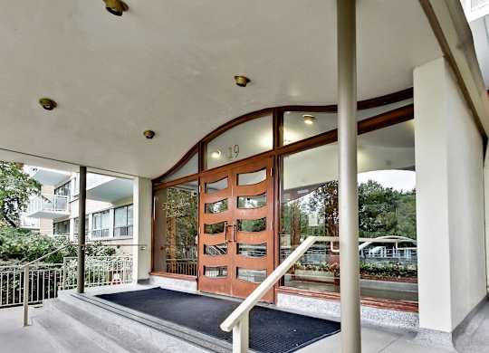 A building entrance with a black mat on the steps.