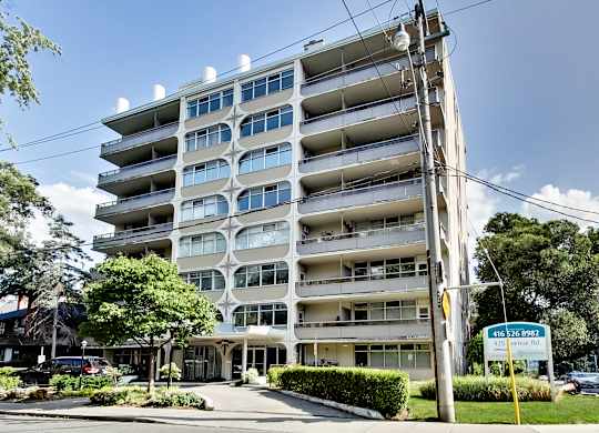 A tall residential building with a sign in front of it.