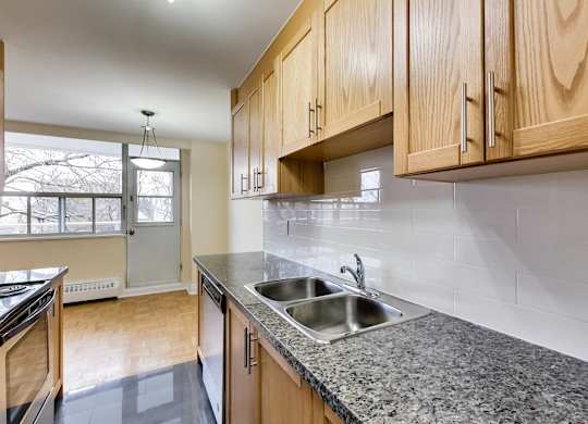 A kitchen with wooden cabinets and a granite countertop.