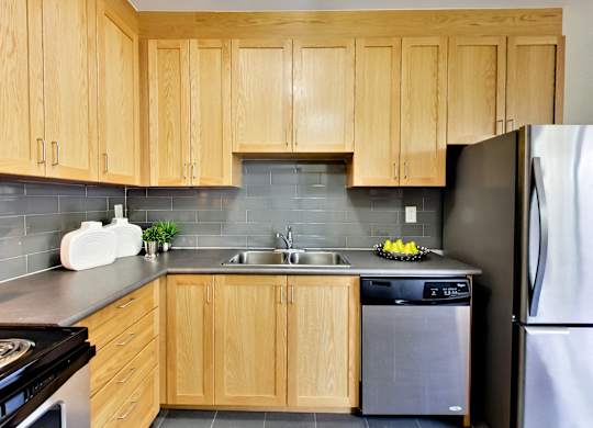 a kitchen with wooden cabinets and stainless steel appliances