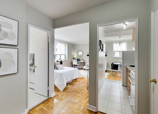 a bedroom and a living room with a bed and a kitchen
