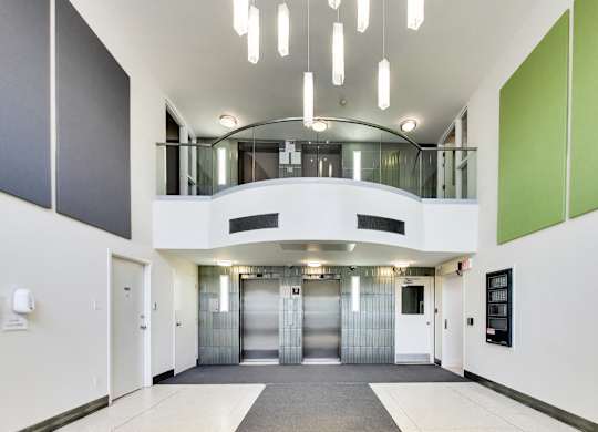 A hallway with a white floor, white walls, and a green accent wall.