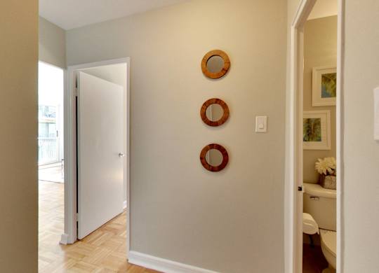 a hallway with three round mirrors on the wall