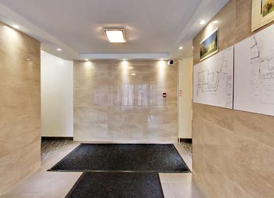 a long hallway with whiteboards on the wall and black rugs on the floor