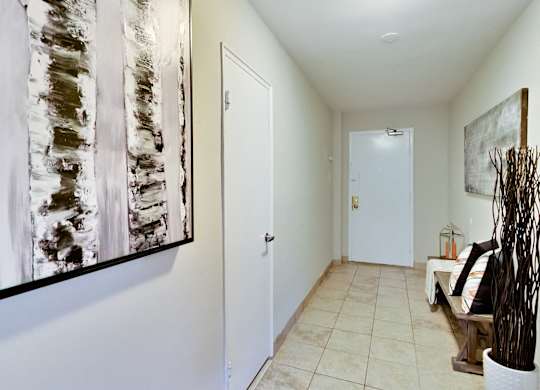 a hallway with a white door and a painting on the wall