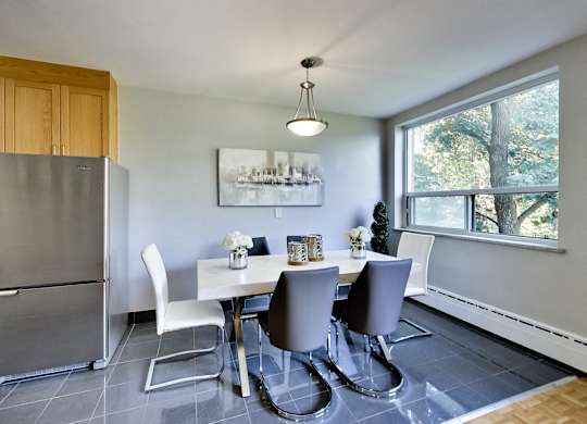 a dining room with a white table and chairs and a large window