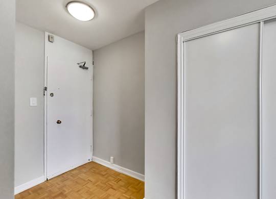 a bedroom with a door to a closet and a wood floor