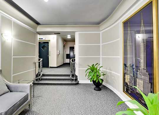 a lobby of a hotel with a plant and a staircase