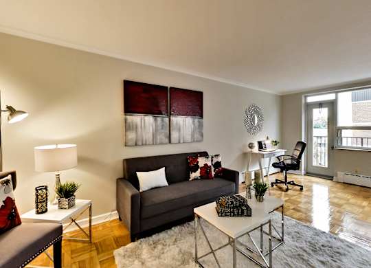 a living room with a couch and a chair and a desk