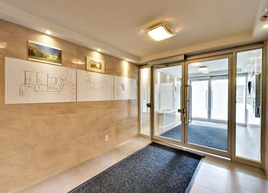 a lobby with glass doors and drawings on the wall