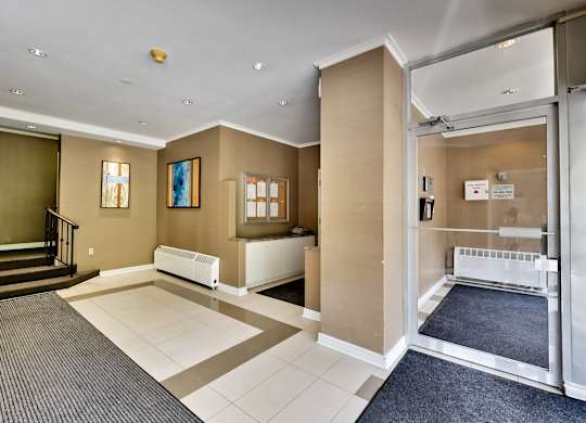 a view of a lobby with a baby crib and a glass door