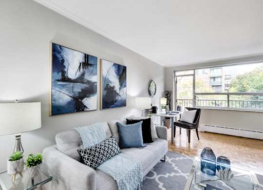 a living room with a couch and a table with a chair and a window