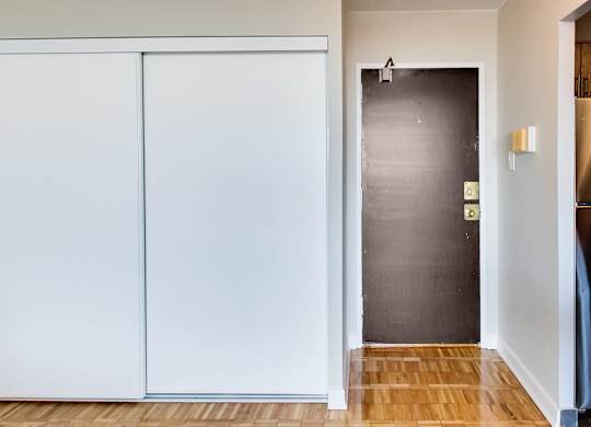 a hallway with white walls and a black door