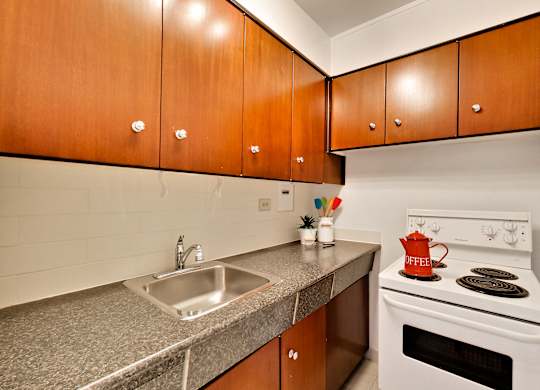 A kitchen with a white stove and a sink.