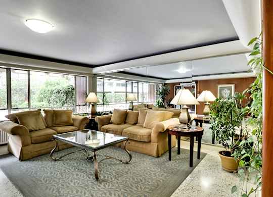 a living room with couches and a glass table