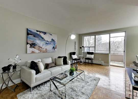 a living room with a white couch and a glass coffee table