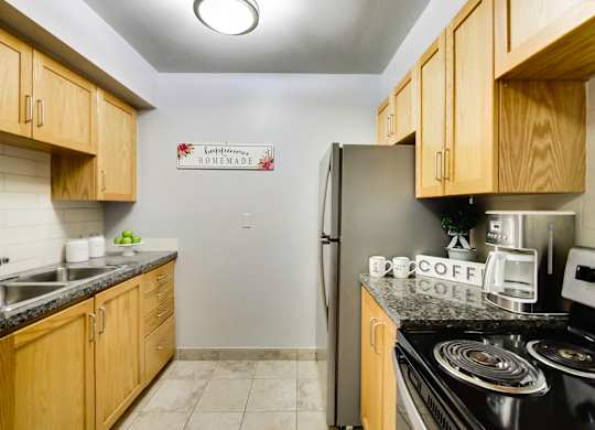 A kitchen with wooden cabinets and a sign that says