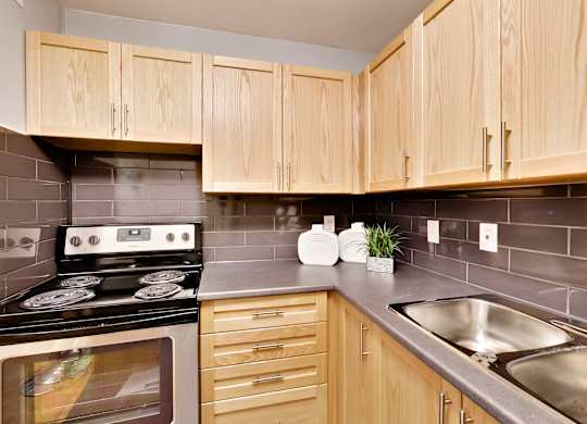 the kitchen has stainless steel appliances and wood cabinets