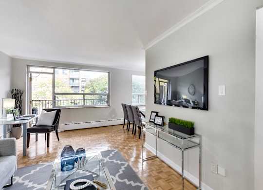 a living room with a tv and a table and chairs