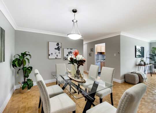 A dining room with a glass table and chairs.