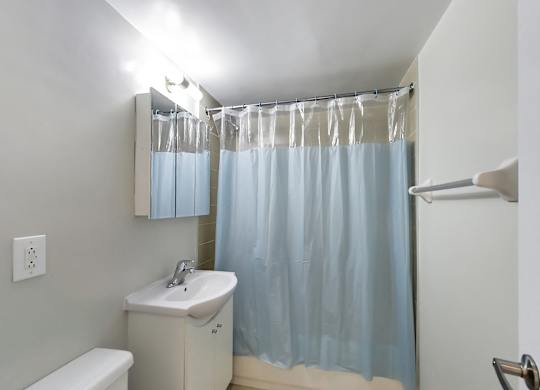 a bathroom with a blue shower curtain and a sink