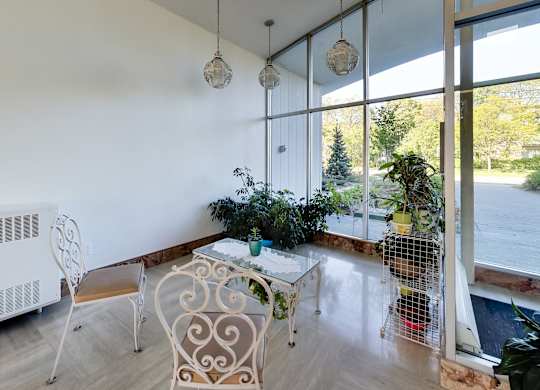 a living room with a table and chairs and a large window