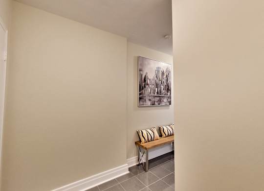 a hallway with a bench and a painting on the wall