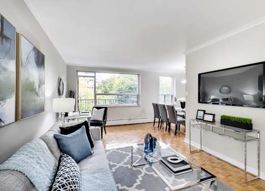 a living room with a couch and a glass coffee table and a television