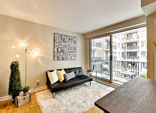 a living room with a couch and a table and a balcony