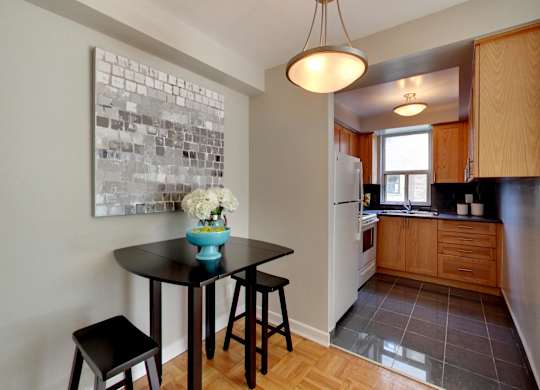a kitchen with a black table and stools in front of a window