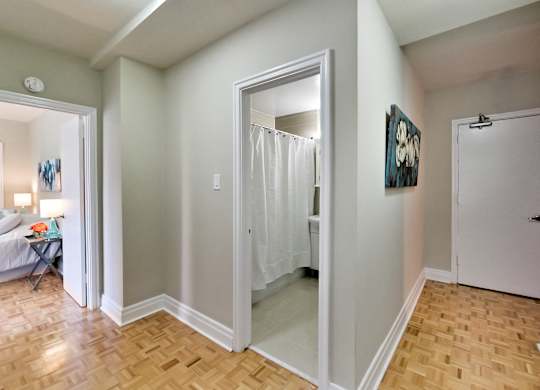 a renovated living room with a sliding glass door to a bathroom and a bedroom with