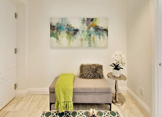 a living room with a couch and a painting on the wall