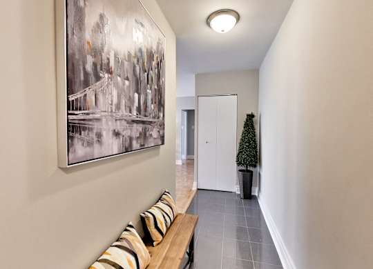 a hallway with a wooden bench and a painting on the wall