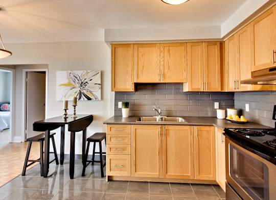 a kitchen with wooden cabinets and a table with stools
