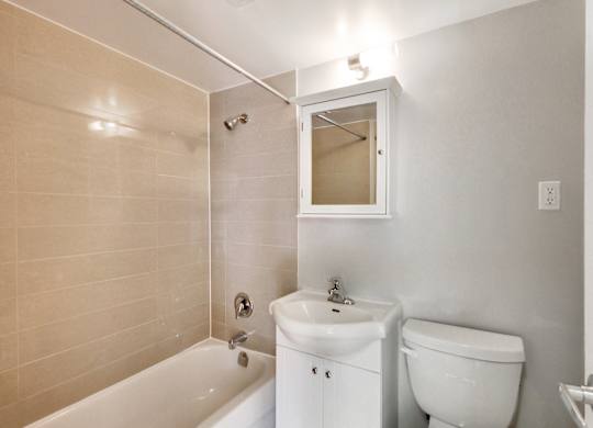 a bathroom with a toilet and a tub and a sink