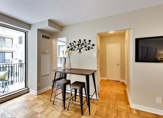 a dining room with a table and stools and a large window