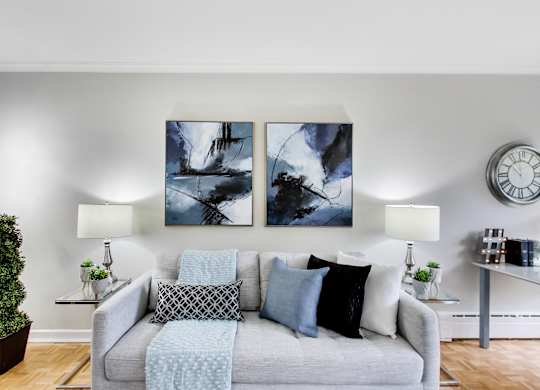 a living room with a couch and two paintings on the wall