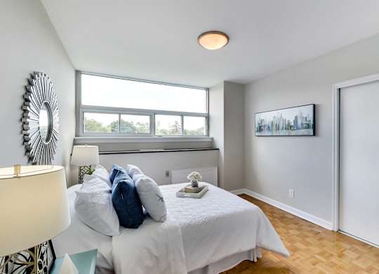 an empty bedroom with a bed and a window
