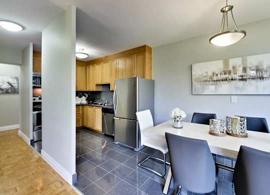 a kitchen and dining room with stainless steel appliances and a table and chairs