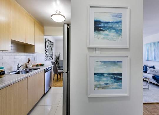 a kitchen and living room with two pictures on the wall