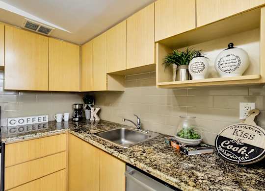 A kitchen with wooden cabinets and a granite countertop.