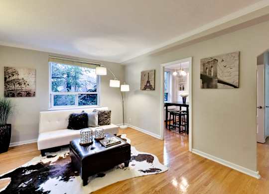a living room with a couch and a table in front of a window