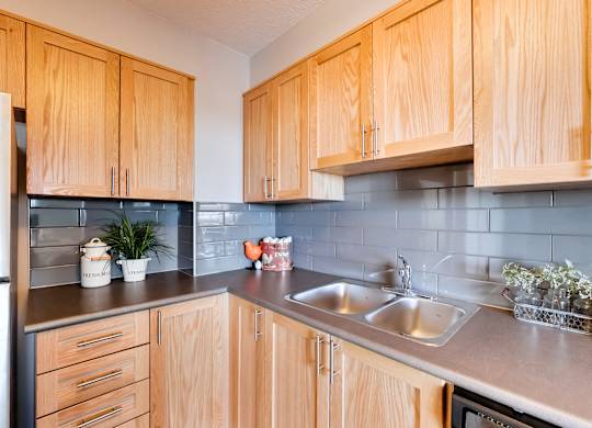 a kitchen with wooden cabinets and a stainless steel sink