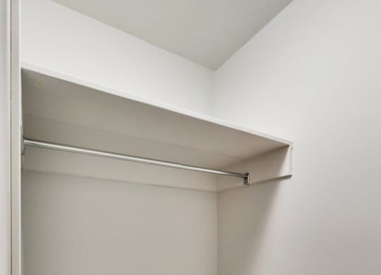 an empty closet with a white shelf in it