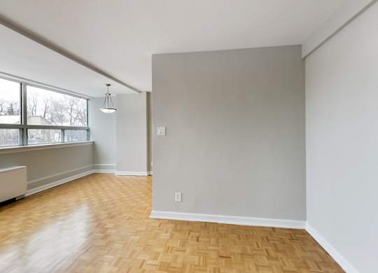 an empty living room with wood floors and a large window