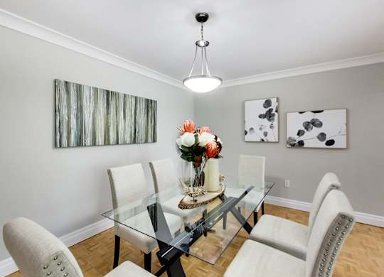 A dining room with a glass table and chairs.