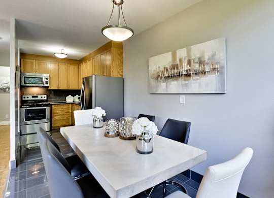a kitchen and dining room with stainless steel appliances and a table and chairs
